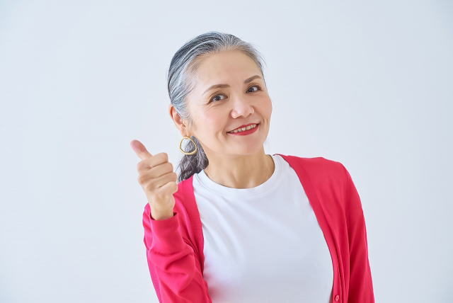親指を立てる高齢の女性の画像
